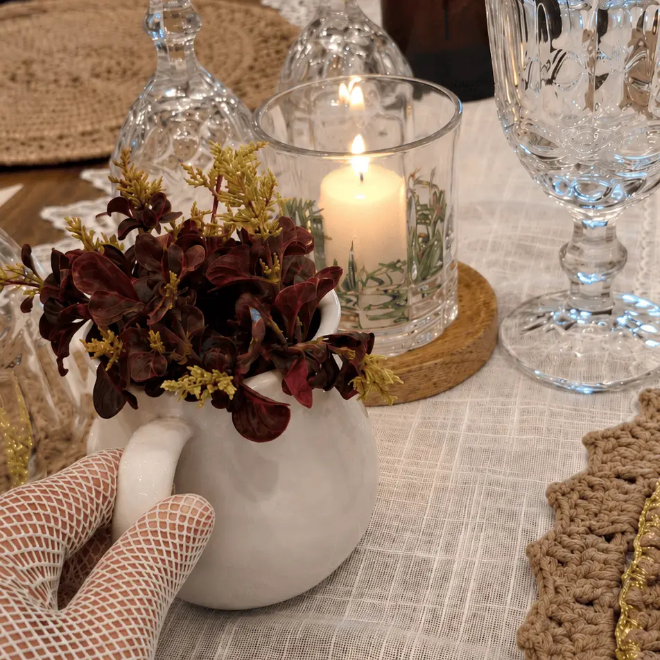 Arranjo de flores e vela sobre a mesa posta